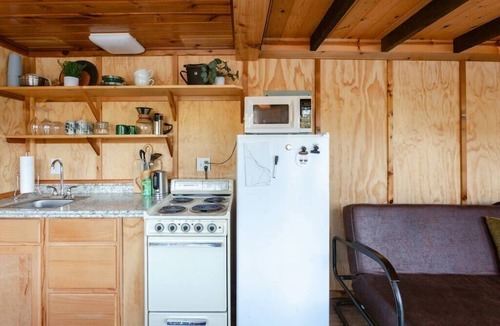 Lakeside Cabin | Remote 1 BR Lakefront Cabin. Features a King loft bed with lake views, private dock, and provided paddleboards/kayaks. Perfect for fishing, stargazing, and quiet nature escapes.